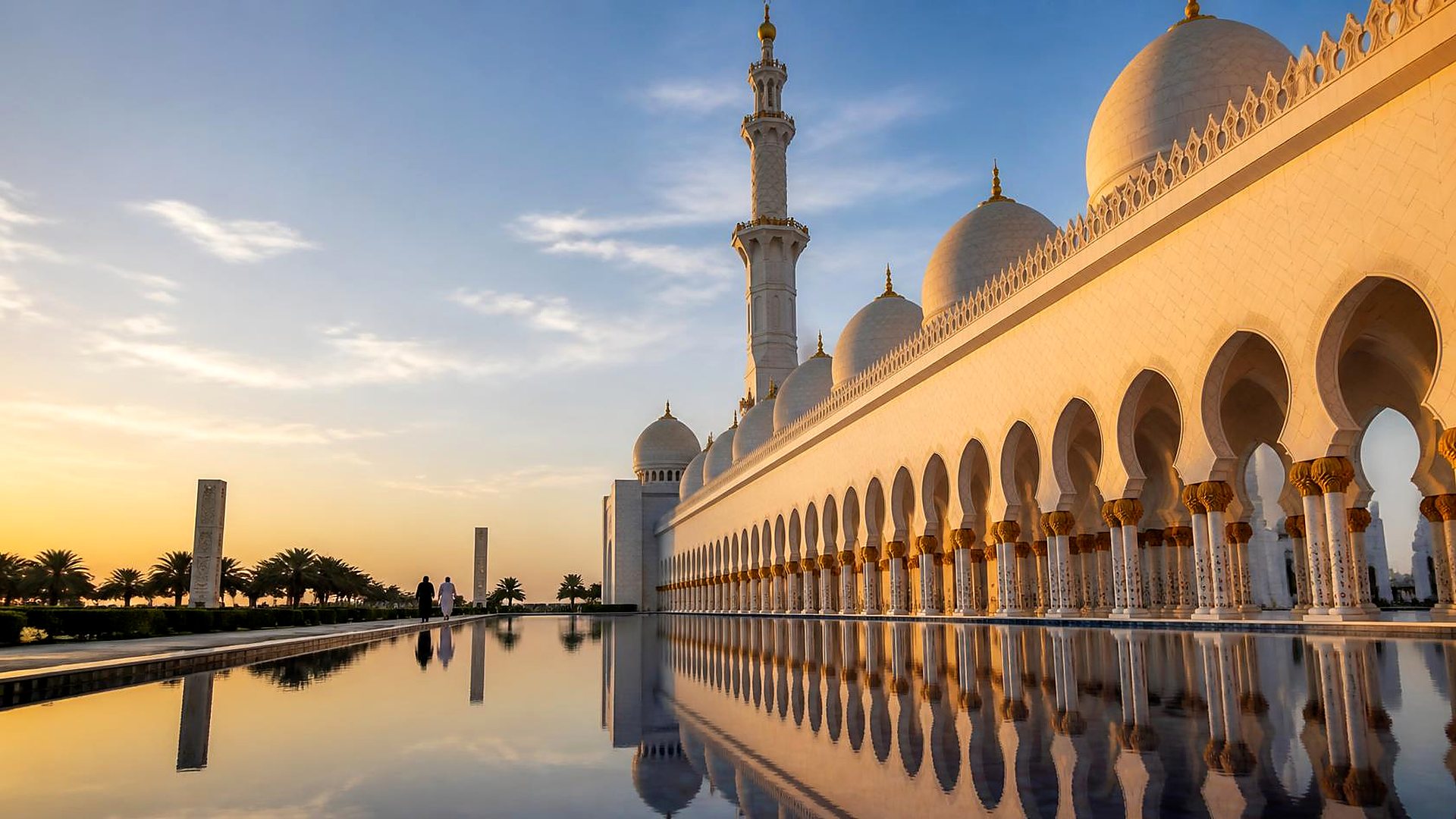 Arcades and minaret of the Sheikh Zayed Grand Mosque reflected in the pools