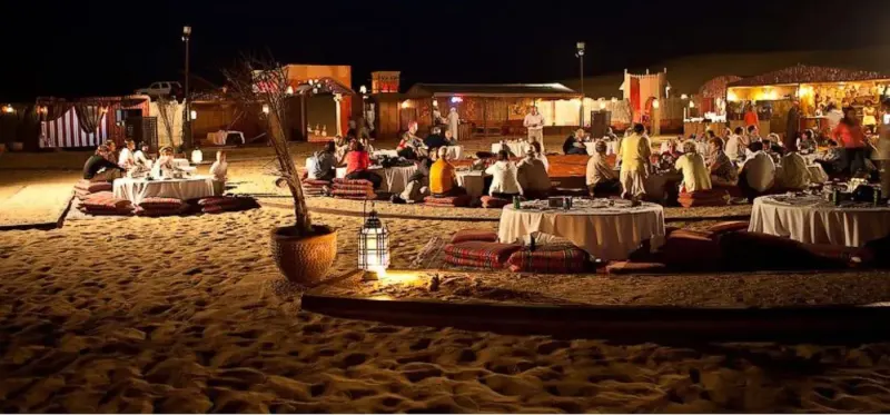 Desert camp with dining tables at night