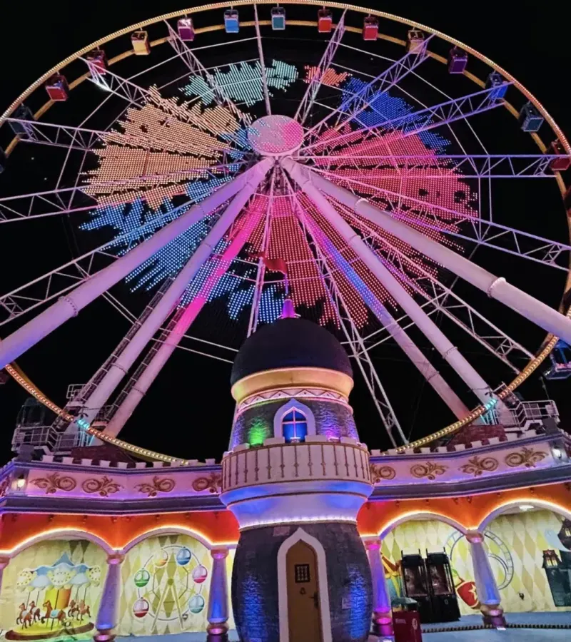 Big wheel and pavilions of Global Village at night