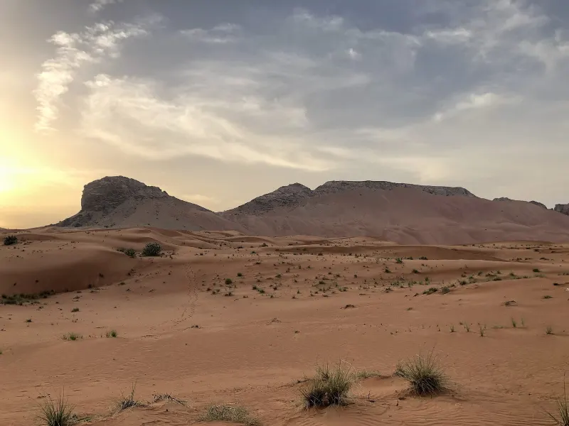 Fossil Rock rising above the red dunes of Sharjah