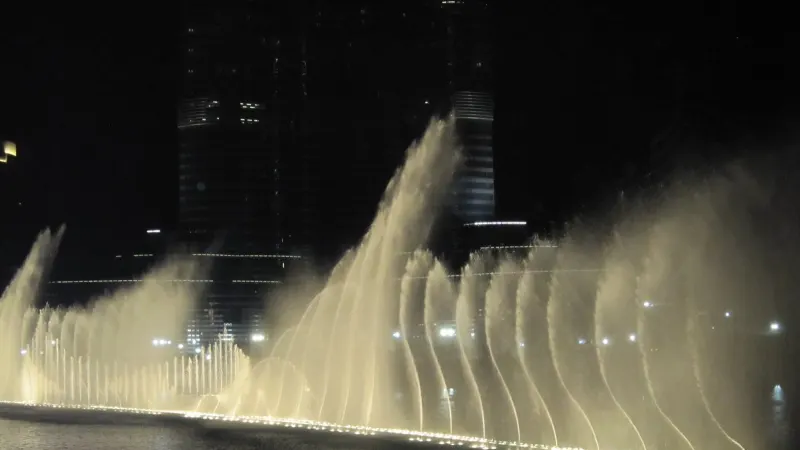 Water jets of the Dubai Fountain in front of the Burj Khalifa at night