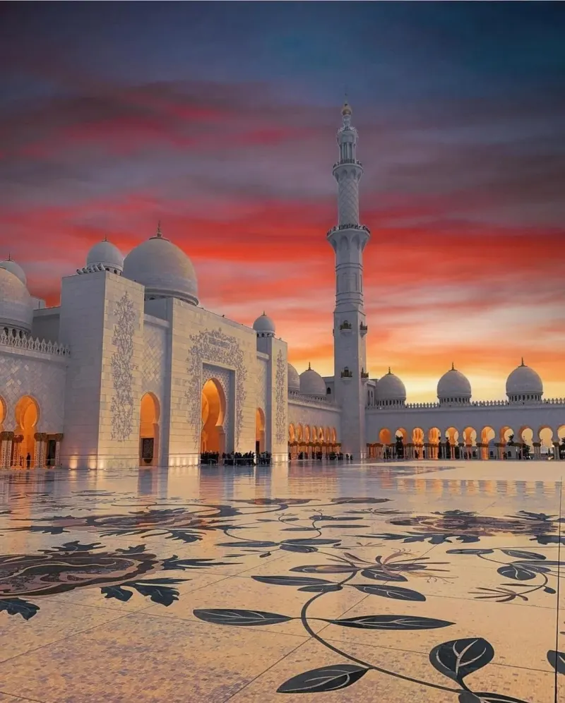 Sheikh Zayed Grand Mosque courtyard under a red sunset sky