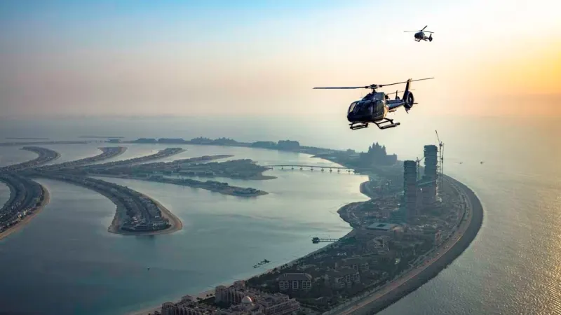 Two helicopters over the Palm Jumeirah at sunset