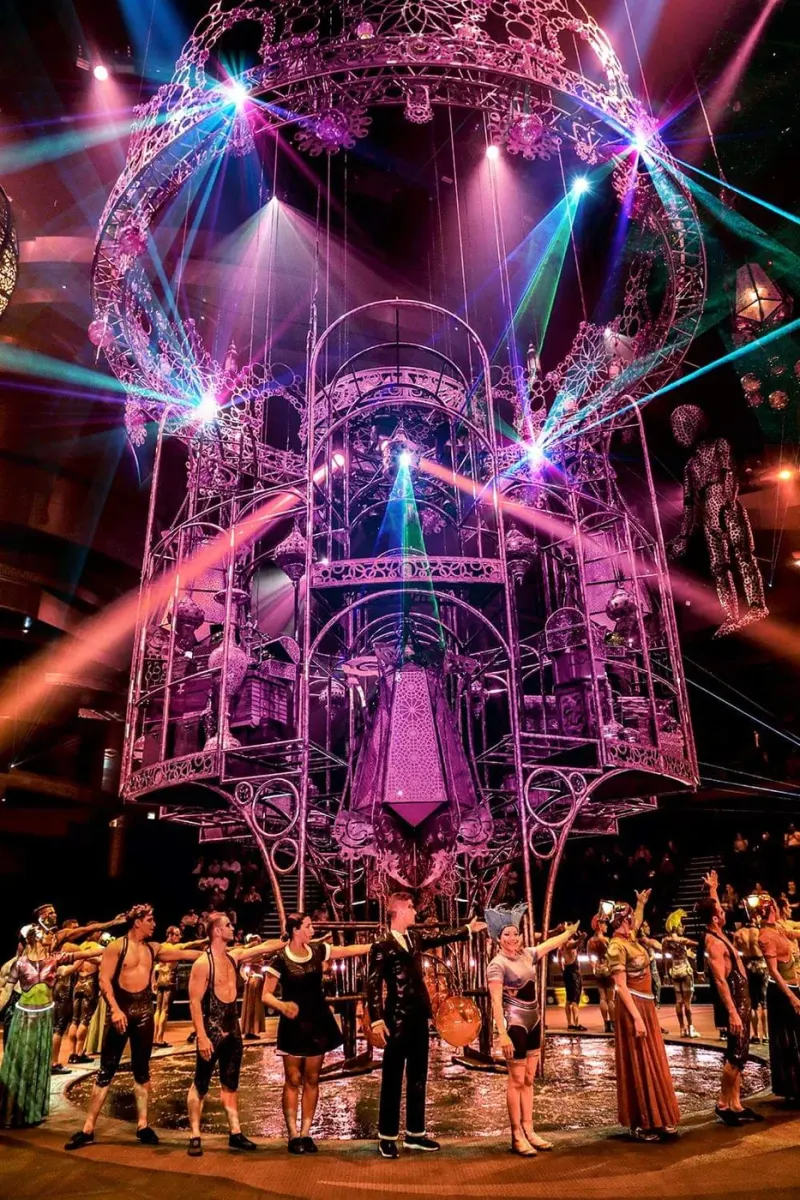 Performers on the stage of La Perle under coloured lights