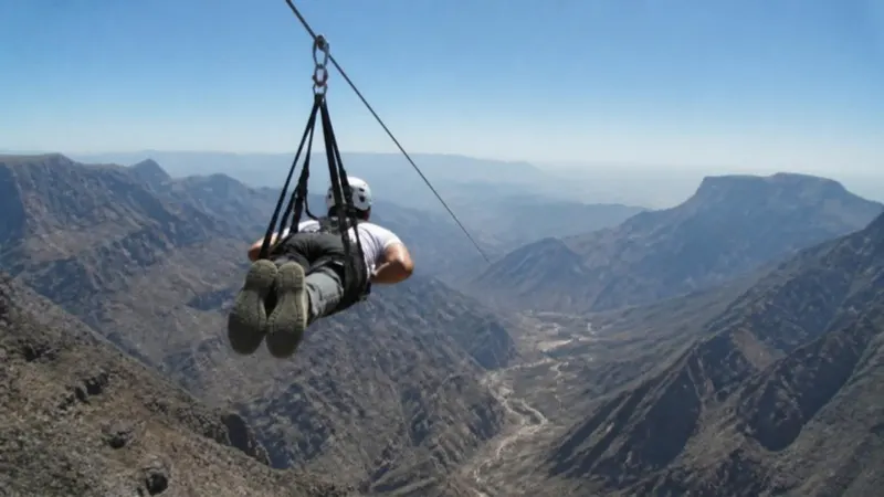 Illustration (generated image): a rider on a zipline over mountains