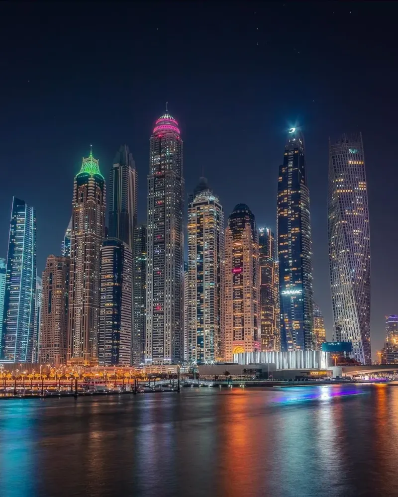 Dubai Marina towers reflected in the water at night